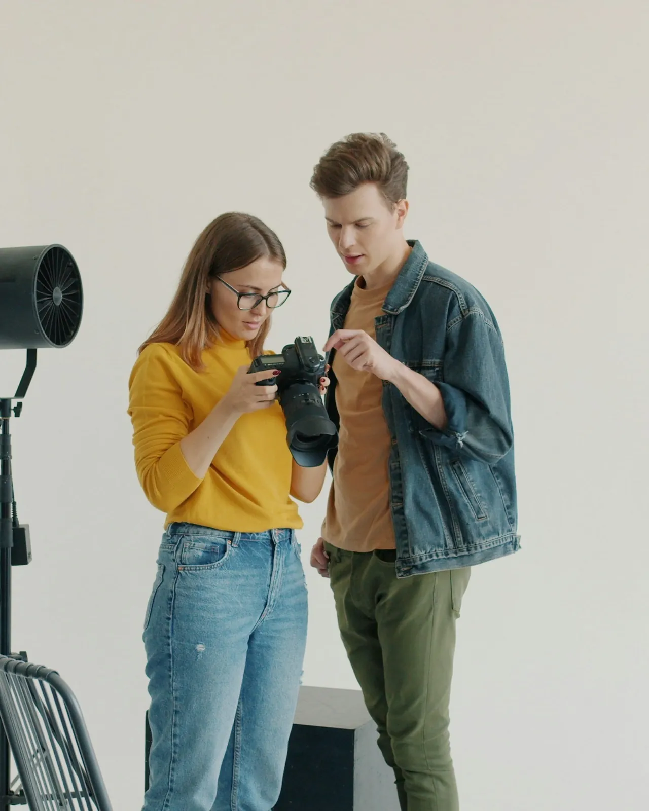 Two people reviewing a camera together in a photo studio